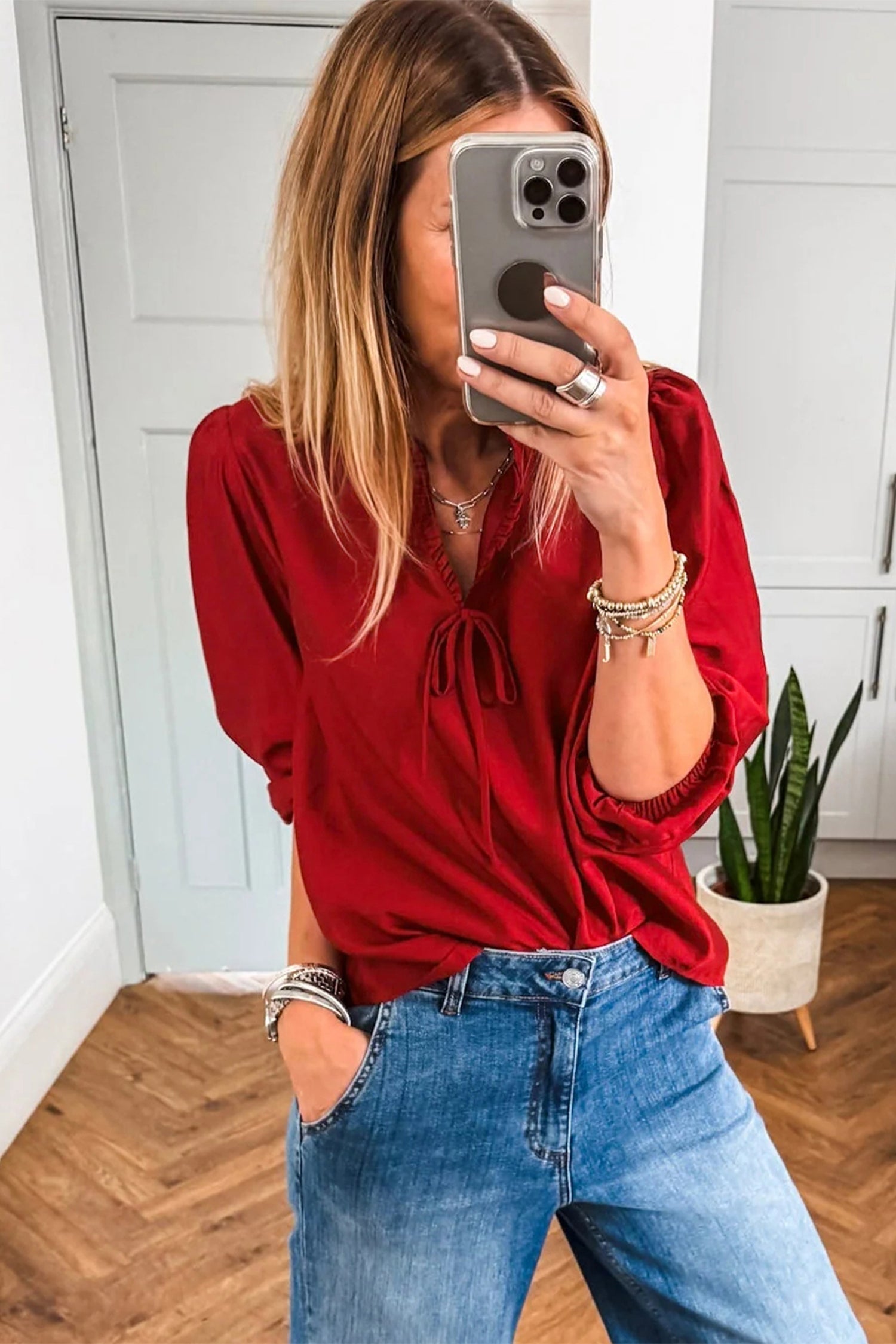 Red Frilled Blouse Selfie: Woman in stylish V-neck bow top and jeans, showcasing Pretty Melanin Boutique fashion.