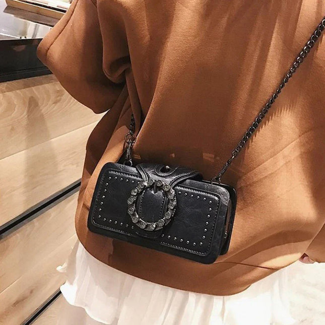 Black crossbody bag with rhinestone buckle and rivets, vintage punk style shoulder bag for women.