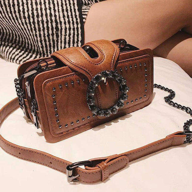 Brown leather punk style shoulder bag with rhinestone buckle and chain strap for women.