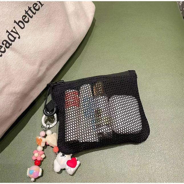 Black mesh makeup bag with lipsticks, keychain charms, coin purse, and card holder - portable travel essential.